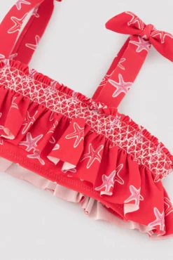 Bikini niña detalles volantes y nido de abeja estampado estrellas marinas rojo