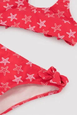 Bikini niña detalles volantes y lazos estampado estrellas marinas rojo