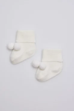 Calcetines canalé con borlas recién nacido marfil