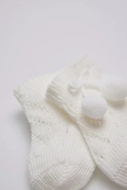Calcetines perlé con borlas recién nacido marfil