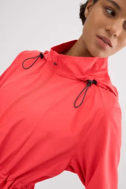 Chaqueta deportiva cortavientos con capucha y bolsillos coral