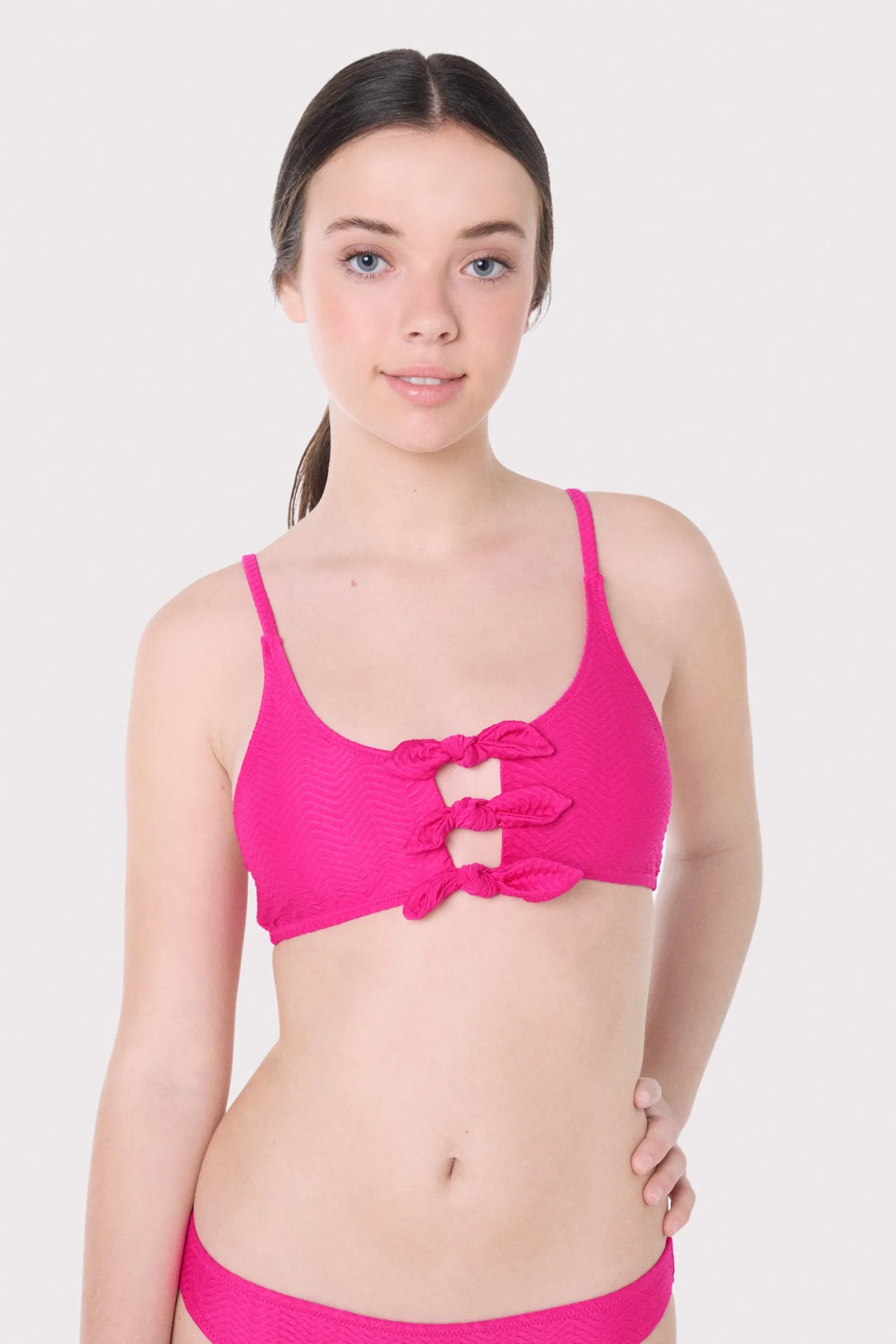 Top bikini juvenil texturizado detalles lazos fucsia