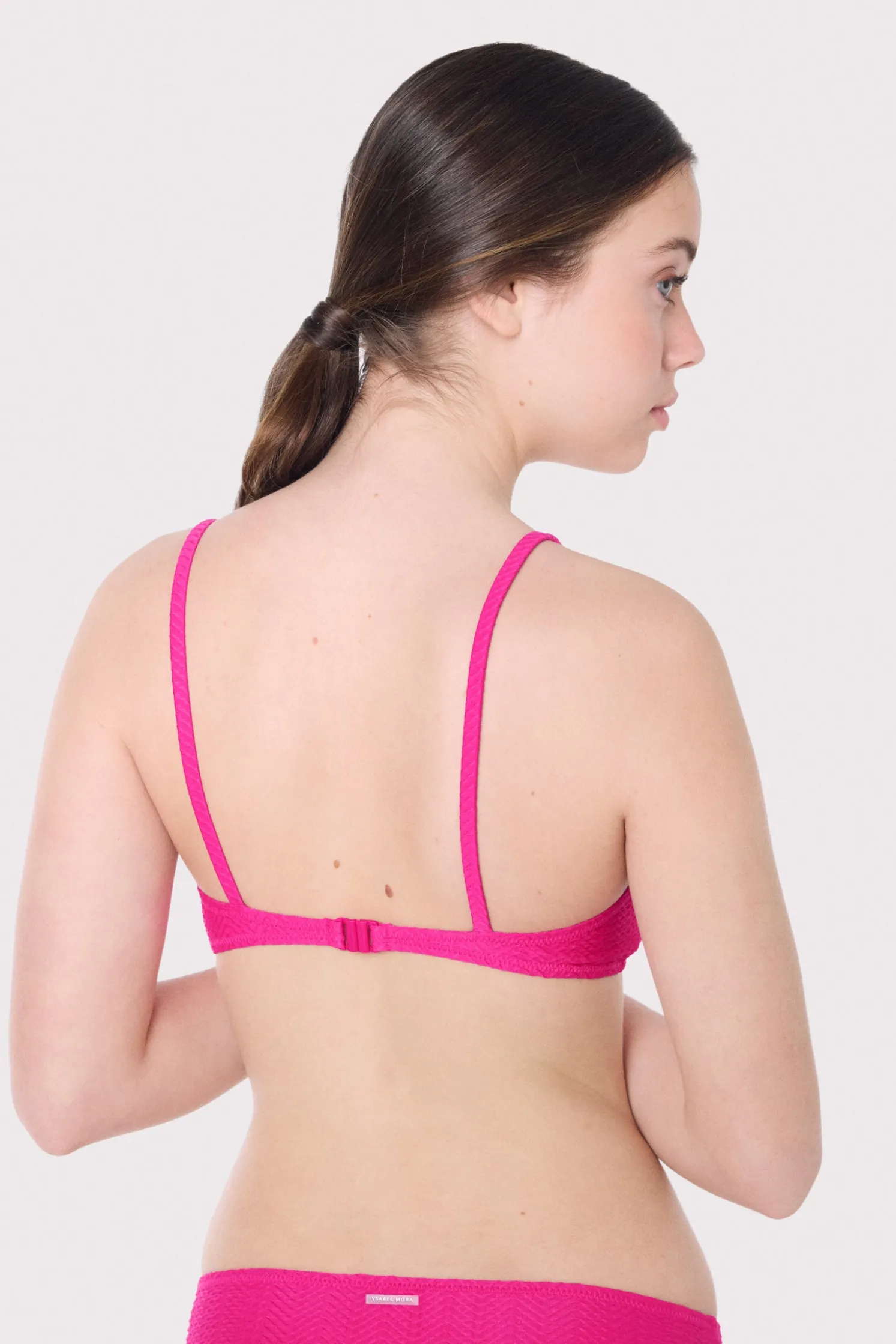 Top bikini juvenil texturizado detalles lazos fucsia